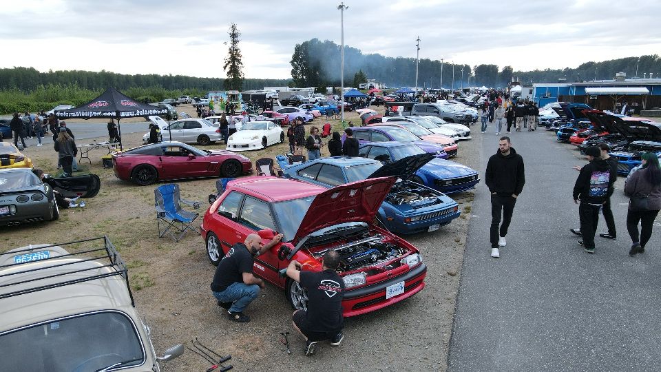 Aerial view of a Lower Mainland car meet with Dent Buster technicians repairing a red car