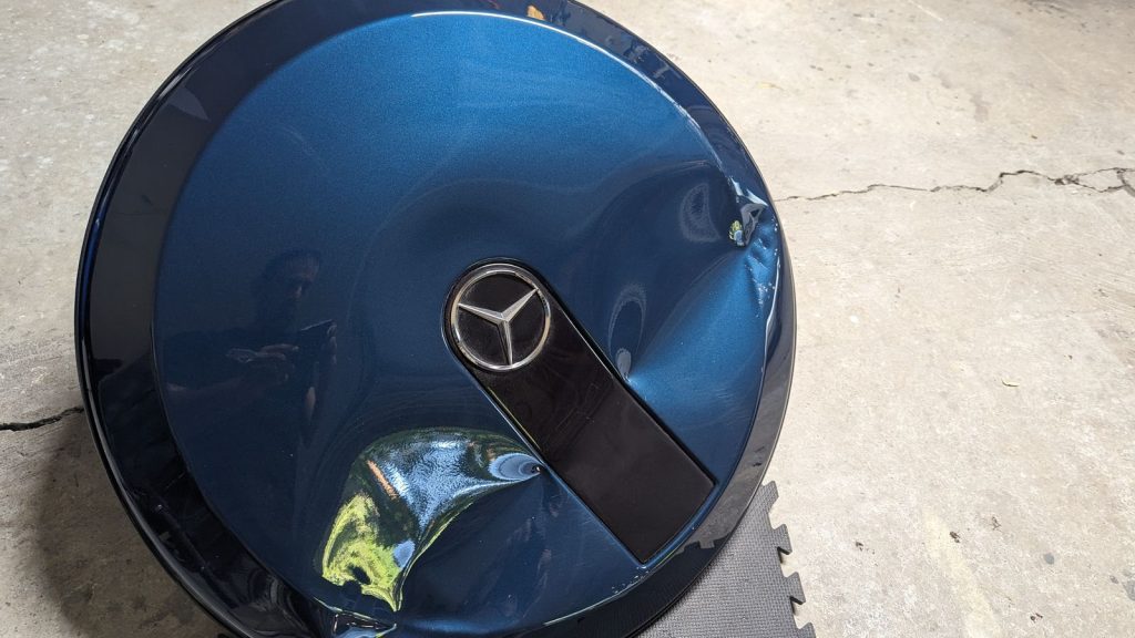 Crushed Mercedes-Benz G-Class spare tire cover before dent repair