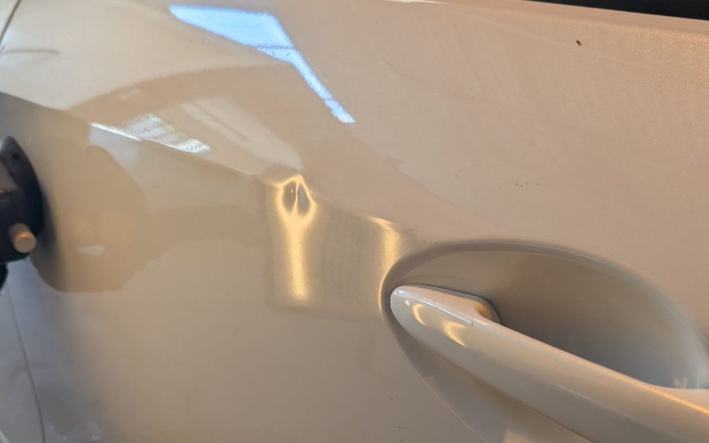 White car door after paintless dent repair, ding removed