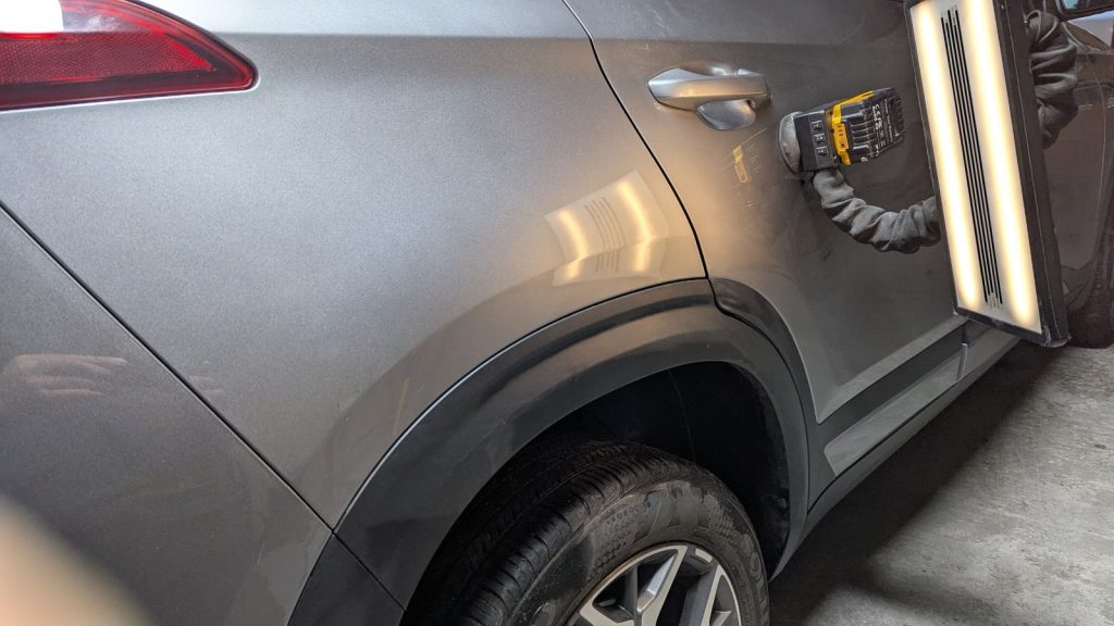 Grey SUV quarter panel after repair, reflection lines straight