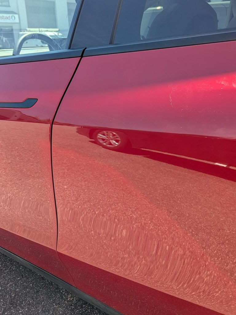 Red Tesla Model Y rear door after paintless dent repair